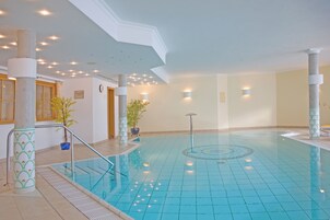 Una piscina techada, sillones reclinables de piscina