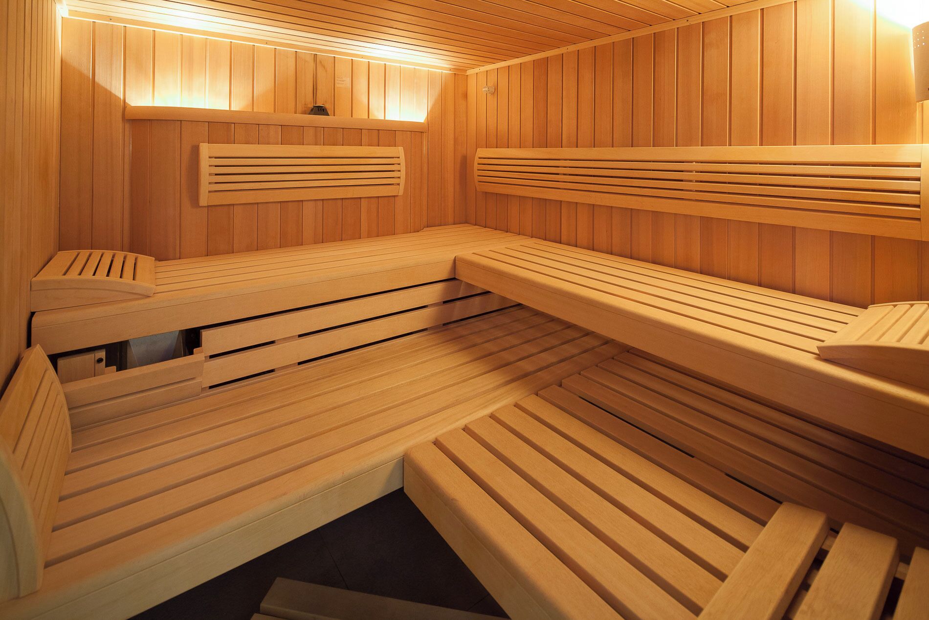 Una sauna con bancos de madera y asientos con respaldo.