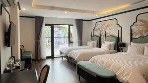 Habitación de hotel con dos camas, una mesa de comedor y un televisor.