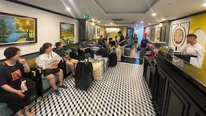 Un hall de hotel con zonas de estar, un mostrador de recepción y obras de arte en las paredes.
