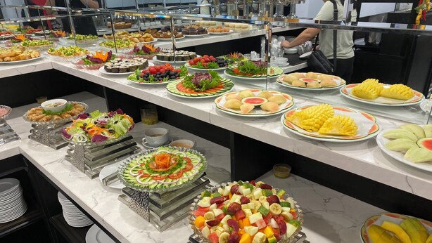 Un bufé con diversas opciones de comida y una barra de ensaladas.