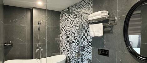Un baño moderno con una bañera independiente, un inodoro y un lavabo con espejo.