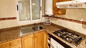 Cafetera o tetera, frigorífico, microondas y placa de cocina