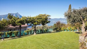 A well-maintained lawn with a house and a mountain view in the background. - Villa Teresa-Lake View (Torri del Benaco)