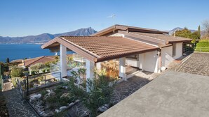 A coastal property with a patio, stone flooring, and a view of the sea and mountains. - Villa Teresa-Lake View (Torri del Benaco)