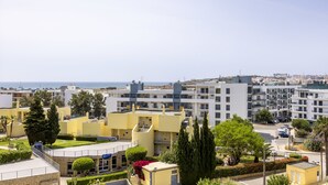A coastal residential area with modern buildings, a clear sky, and a view of the sea. - City & Sea view apartment, Meia Praia Lagos (Lagos)