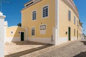 A yellow building with a cobblestone street.