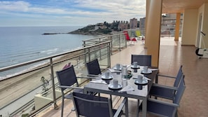 Enjoy a romantic meal for two on this sea-view terrace with a table set and comfortable seating.