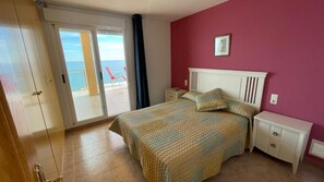 Enjoy a restful stay in this serene room with a large bed, sliding glass door to a balcony, and a beautiful sea view.