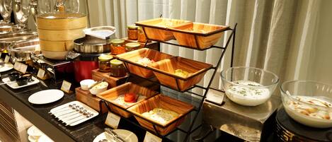 Una mesa de buffet con diferentes alimentos y utensilios.