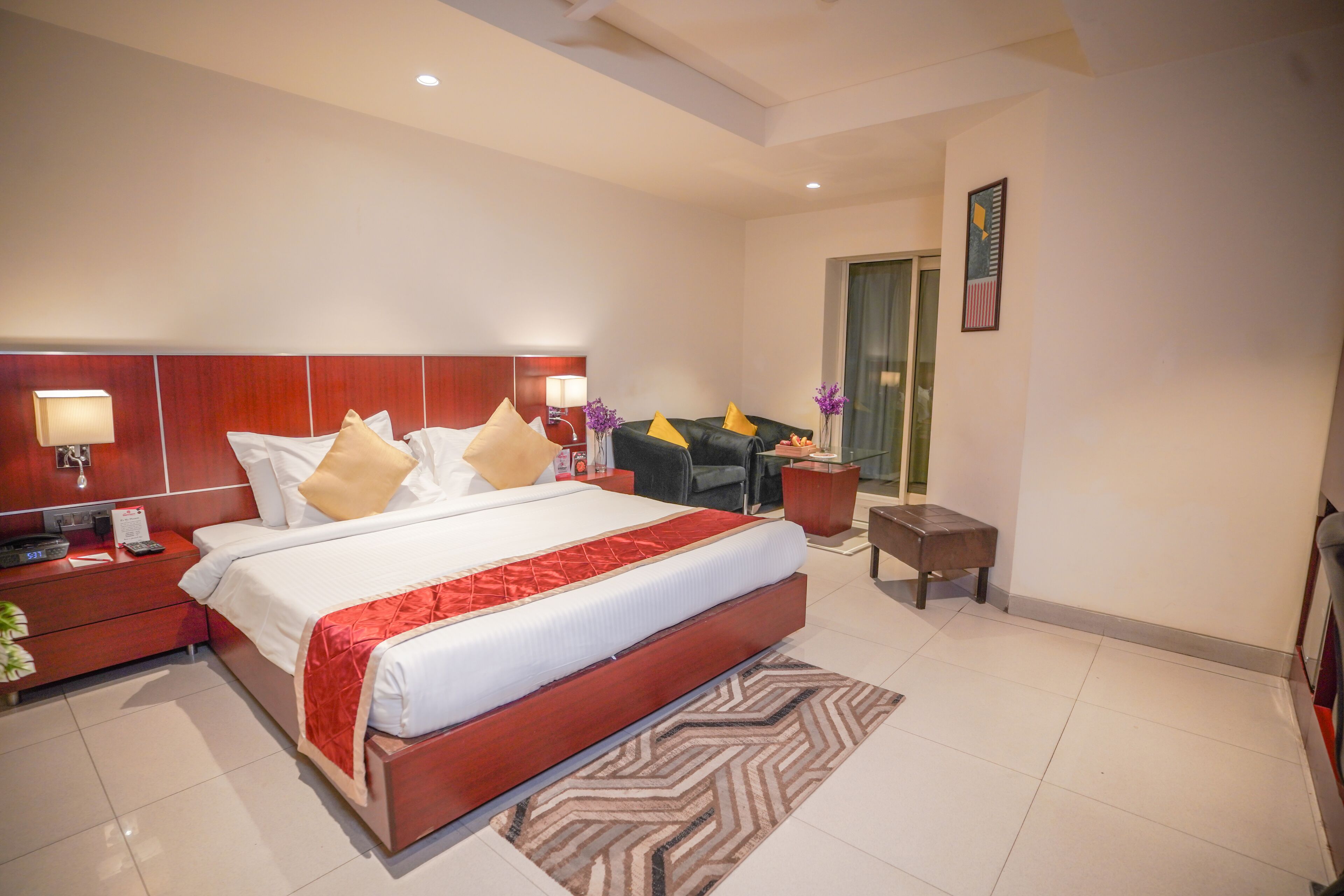 A hotel room with a large bed, bedside tables, a desk, and a chair.