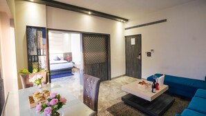 A modern living room with a dining area, a sofa, and a coffee table. - Hotel Swarn Towers (Bareilly)