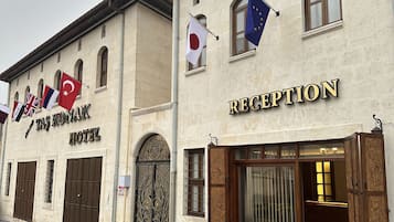 Traditional hotel facade with arched windows and reception area.
