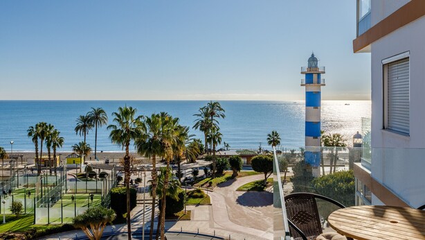 A balcony with a view of the sea, a lighthouse, and palm trees. - A&N Los Angeles (Torre del Mar)