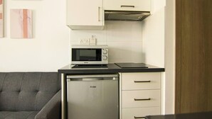 A compact kitchen with a built-in microwave, a dishwasher, and a countertop. - Phaedrus Living: Seaside Luxury Flat Athina 115 (Paphos)