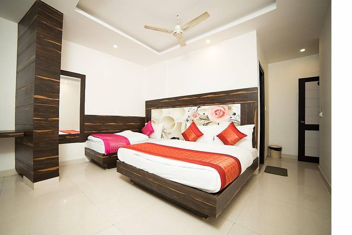 Une chambre d’hôtel moderne, dotée d’un grand lit, d’un bureau et d’un ventilateur de plafond.