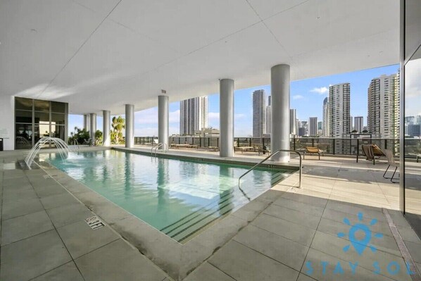 Una piscina en la azotea con vistas despejadas a rascacielos.