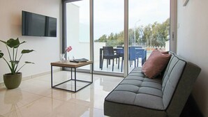 Una sala de estar moderna con un sofá, una mesa de centro y una planta en maceta.