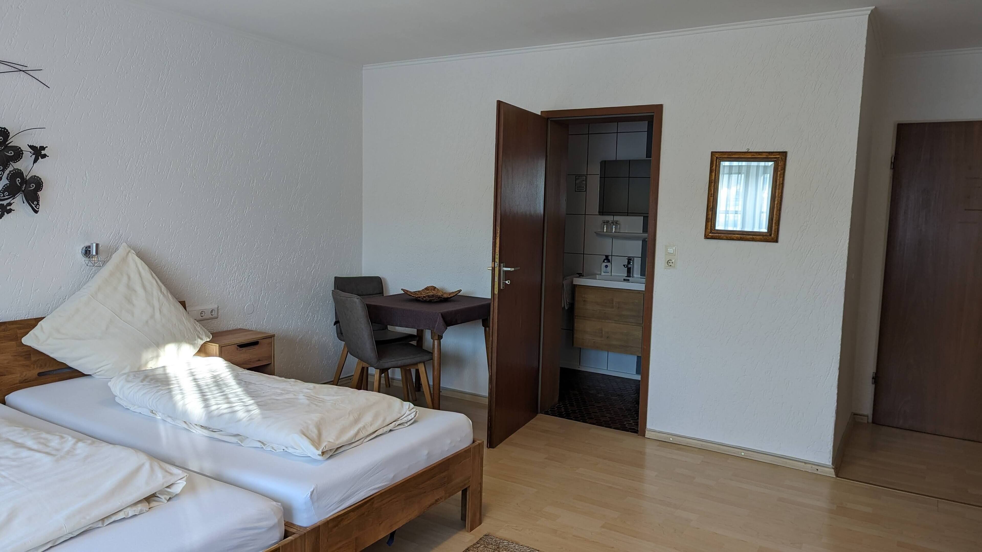 Ein Schlafzimmer mit Bett, Nachttisch und einem kleinen Schreibtisch mit Stuhl.