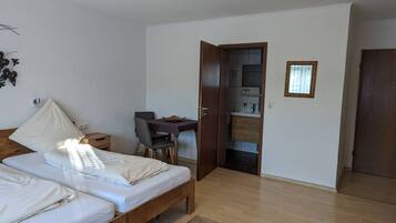 Ein Schlafzimmer mit Bett, Nachttisch und einem kleinen Schreibtisch mit Stuhl.