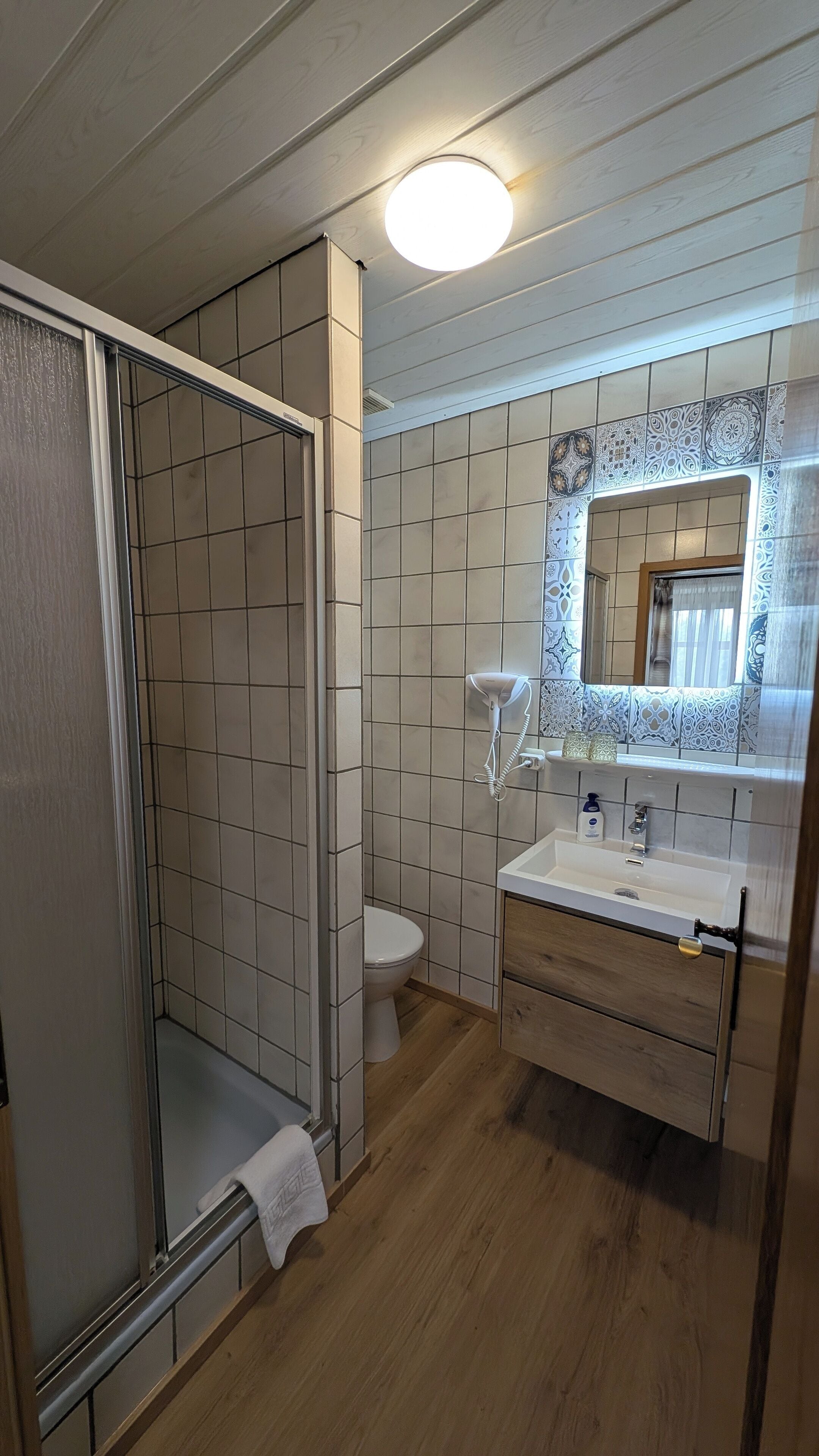 Un baño con ducha, inodoro y lavabo.