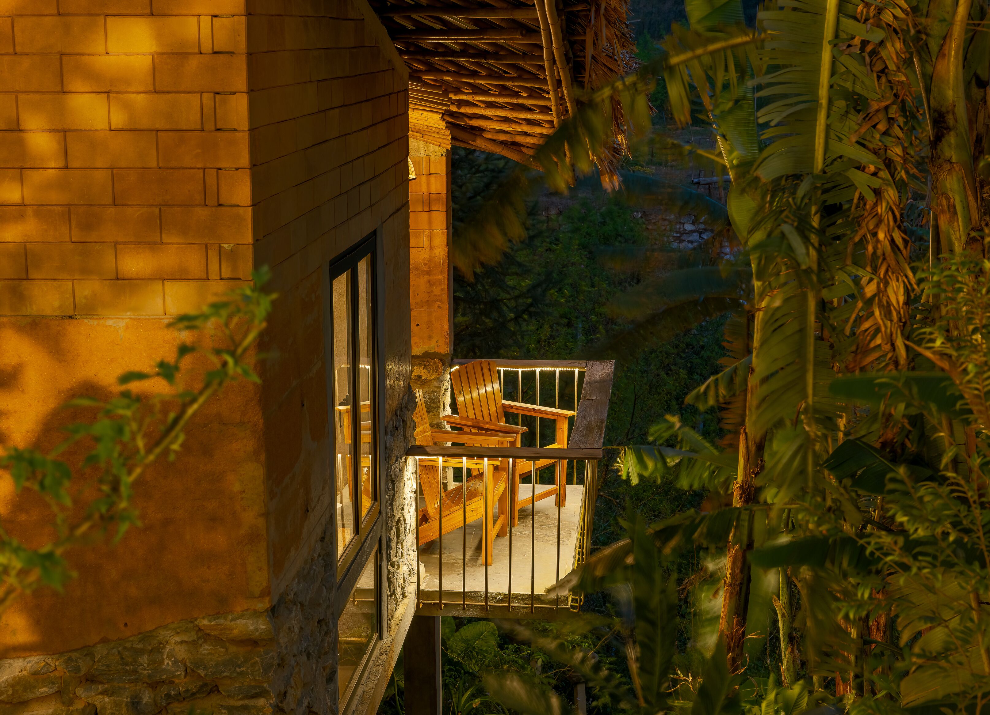 Un balcón de madera con una silla y barandilla, con vistas a un jardín exuberante.