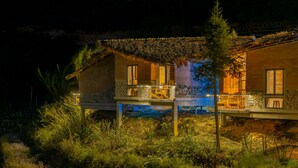 A two-story house with a balcony, surrounded by dense vegetation. - Sapaxa Spring Garden Ecolodge (Ta Phin)