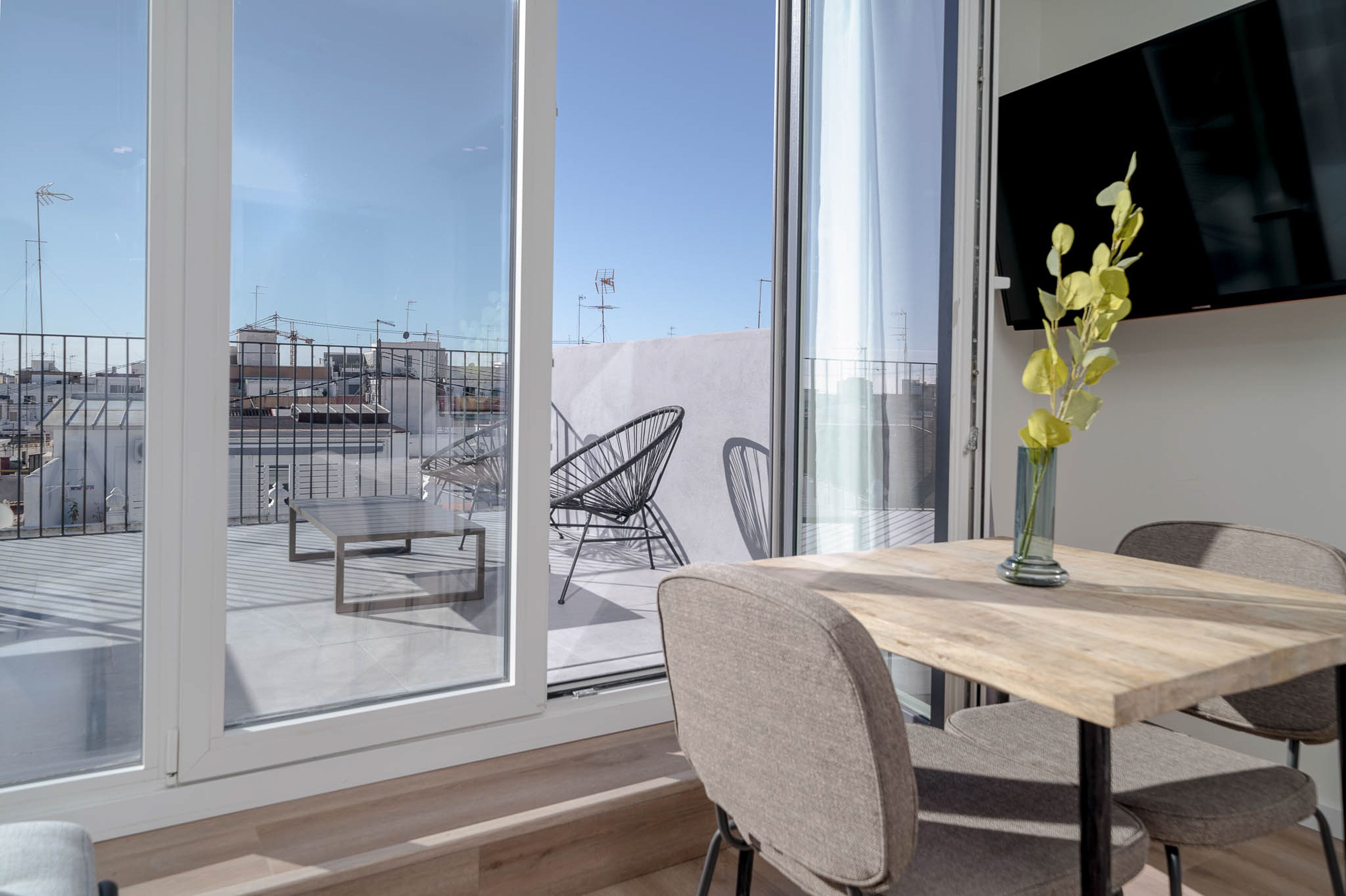 Una habitación moderna con un gran ventanal, una mesa de comedor y una silla.
