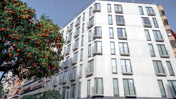 A modern multi-story building with balconies and large windows.