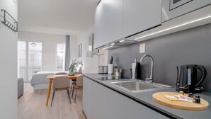 Una cocina moderna con estufa integrada, lavamanos y cafetera.