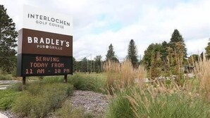 Bordje voor Interlochen Golf Course en Bradley's Pub Grill, met openingstijden van 11:00 tot 22:00 uur.