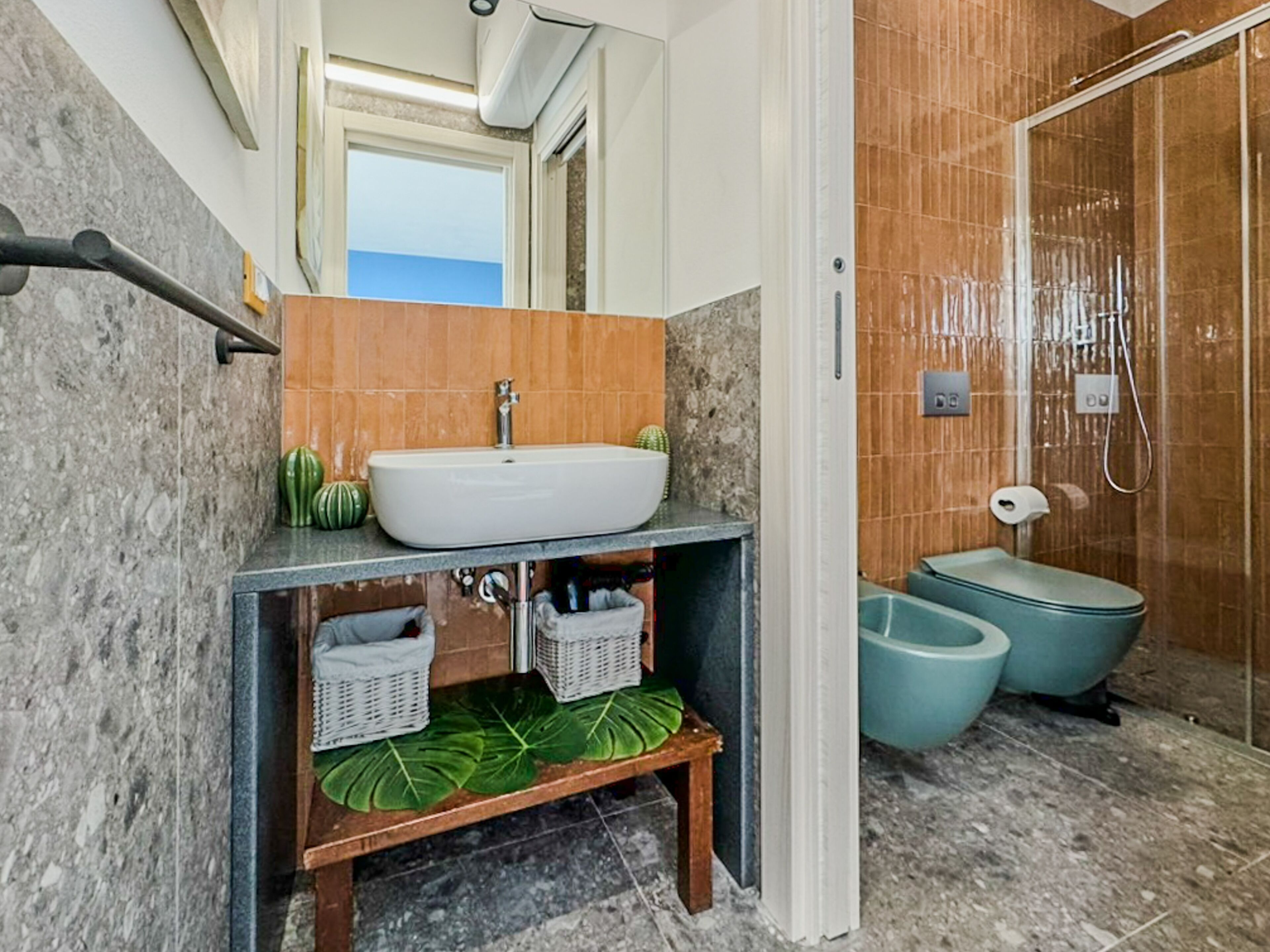 Un baño con lavamanos de mármol, ducha y retrete.