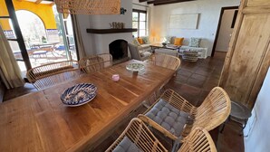 A spacious dining area with a wooden table, wicker chairs, and a hanging light fixture. - Cosy villa with private swimming pool, magnificent views, for 6 PAX (Tarifa)