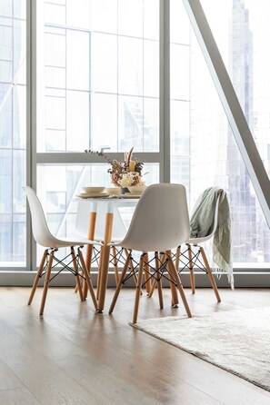 A dining area with a table, chairs, and a view of a cityscape through large windows. - A Lux 2BR Apt Right Opposite Southern Cross (Melbourne)