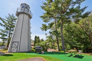 A lighthouse with a grassy area, picnic table, and barbecue grill. - Some'R on the Beach - Beachfront Condo for Six (Wisconsin Dells)