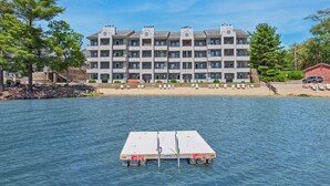 A multi-story hotel with balconies, a dock, and a beachside location. - Some'R on the Beach - Beachfront Condo for Six (Wisconsin Dells)