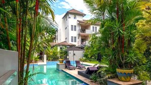A pool area with lounge chairs and a building in the background.