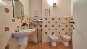 Une salle de bain équipée d’un lavabo, d’un bidet et d’un miroir.