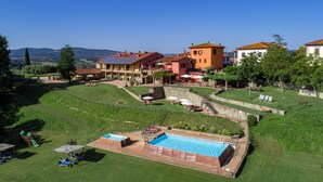 Una extensa propiedad con piscina, mobiliario exterior y vistas al paisaje circundante.