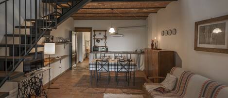 Un loft espaiós amb un sostre alt, parets de maó al descobert, una escala, una zona de dinar i un espai d'estar acollidor.