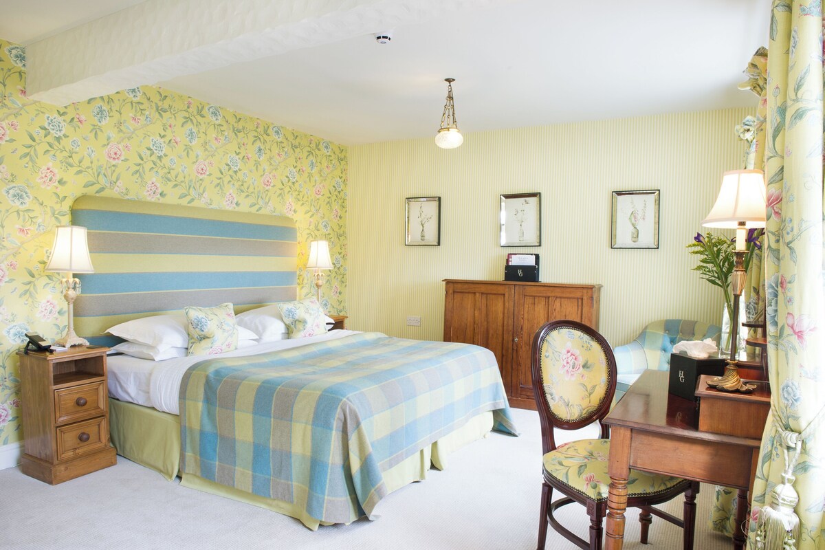 A bedroom with a bed, bedside tables, a desk, and a chair.