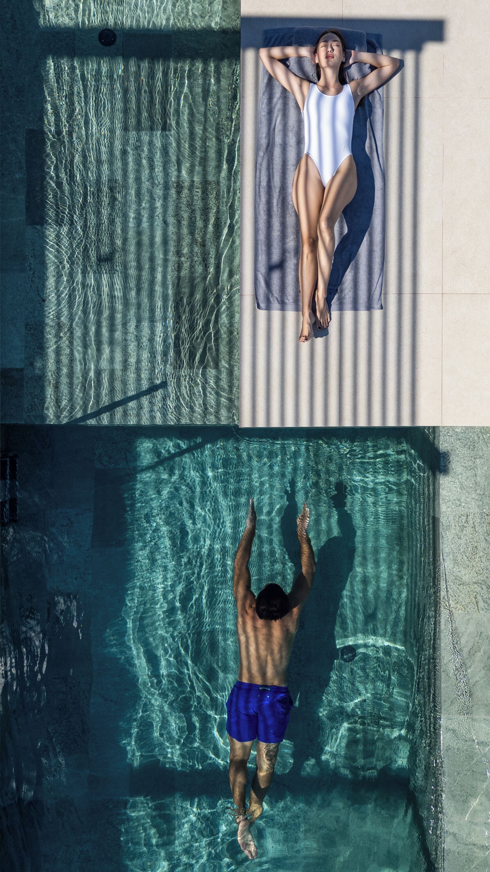 A swimming pool with clear water, a tiled deck, and a person sunbathing on a towel.