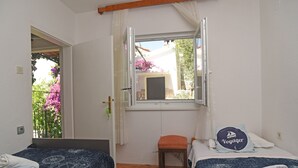 A room with two beds, a window with curtains, a small stool, and a rug with the word "TELIER". - House VERONIKA,sea views, charming terrace,tranquility and natural beauty. (Drvenik Veliki)