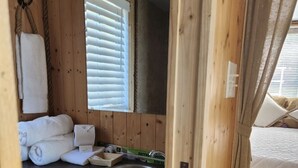 A compact bathroom with a wooden interior, a sink, and a window with blinds. - Unique Lakefront House Boat at Long Cove Resort (Charlotte)