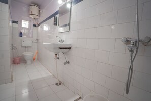 Un baño con inodoro, lavamanos y ducha.