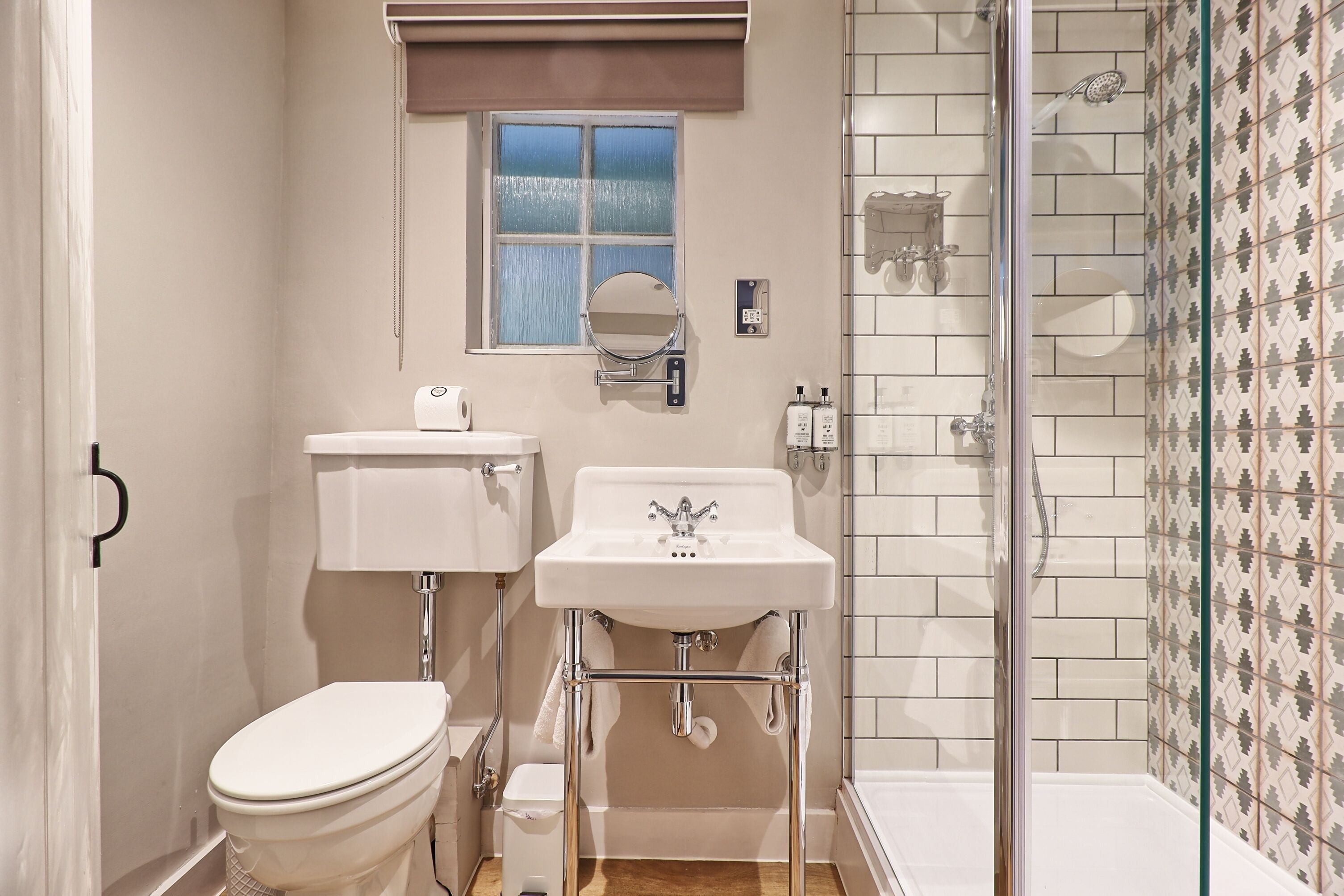 Un baño pequeño con inodoro, lavamanos y ducha.