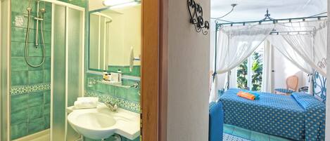 A bathroom with a shower, sink, and mirror. There is a bed with a canopy and a view of the outdoors.