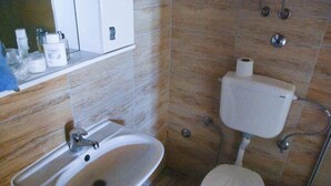 A bathroom with a sink, toilet, and storage cabinet. - Genti House Ada Bojana (Ulcinj)