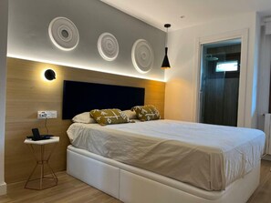 Relax in a serene bedroom with a large bed and ambient lighting options.