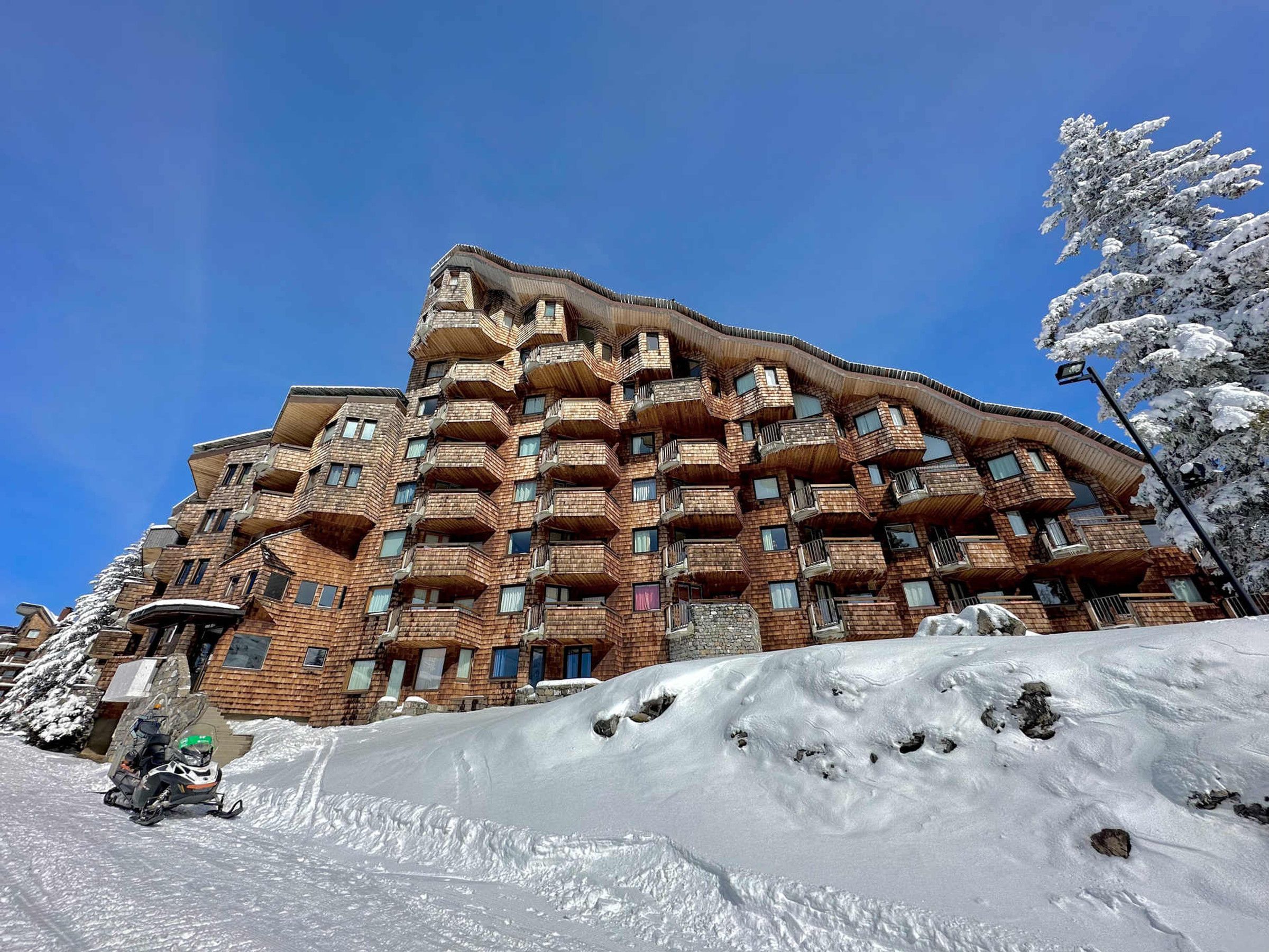 A multi-story building with a unique architectural design, featuring balconies and windows.